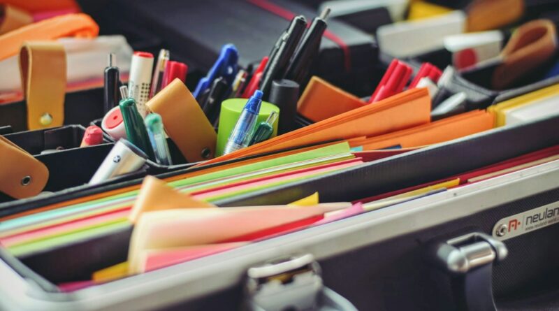 assorted pen and colored papers in organizer case